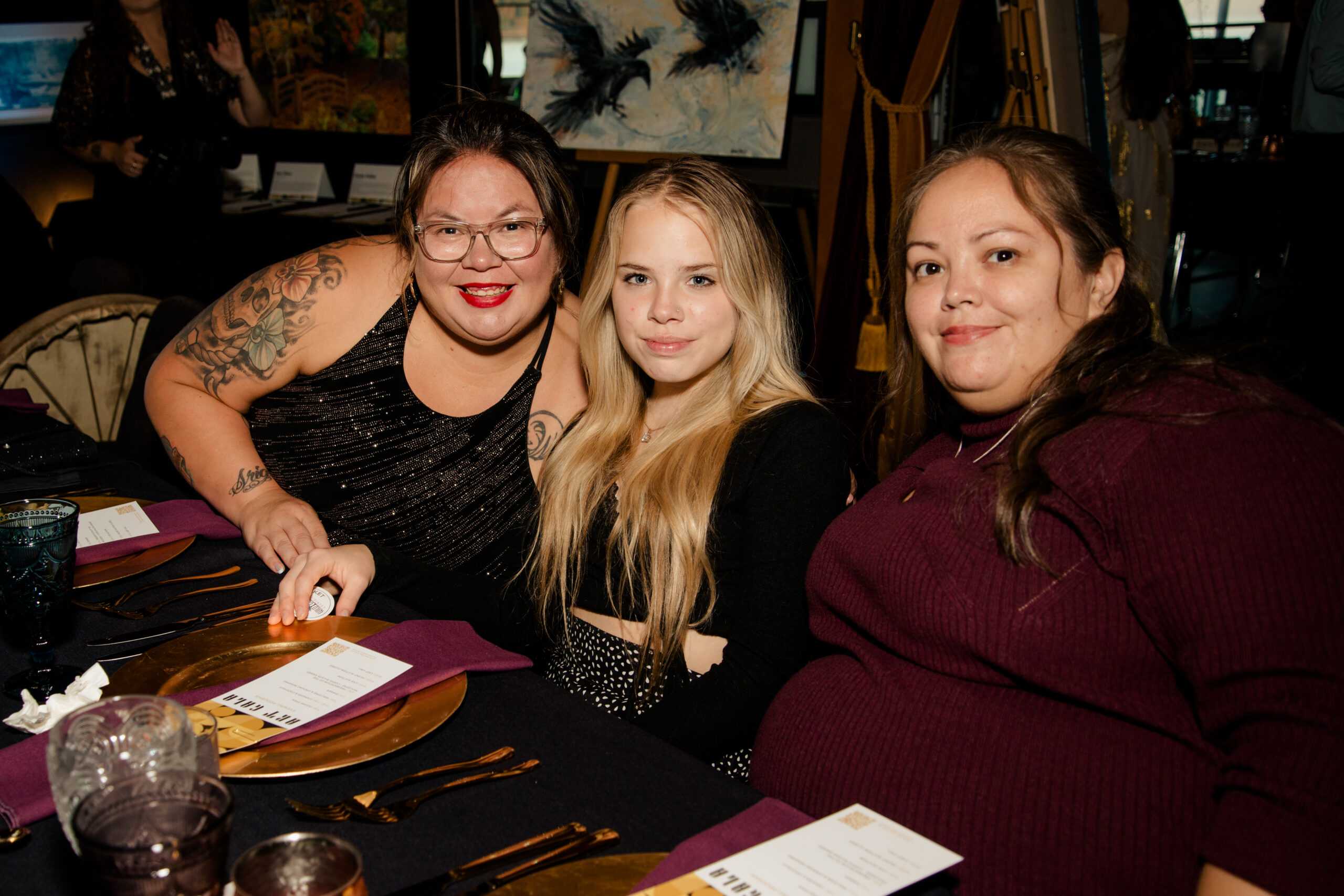 Three women posing at a table